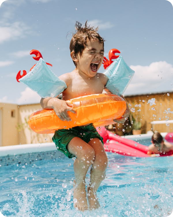 Child jumping into the pool with a floatie at Revelry