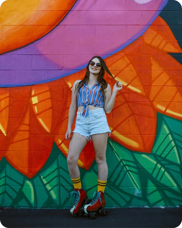 Woman posing at a colorful mural in the Revelry community